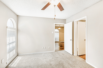Bedroom with carpet, ceiling fan, large window with blinds, en-suite bathroom and wood flooring in dining room